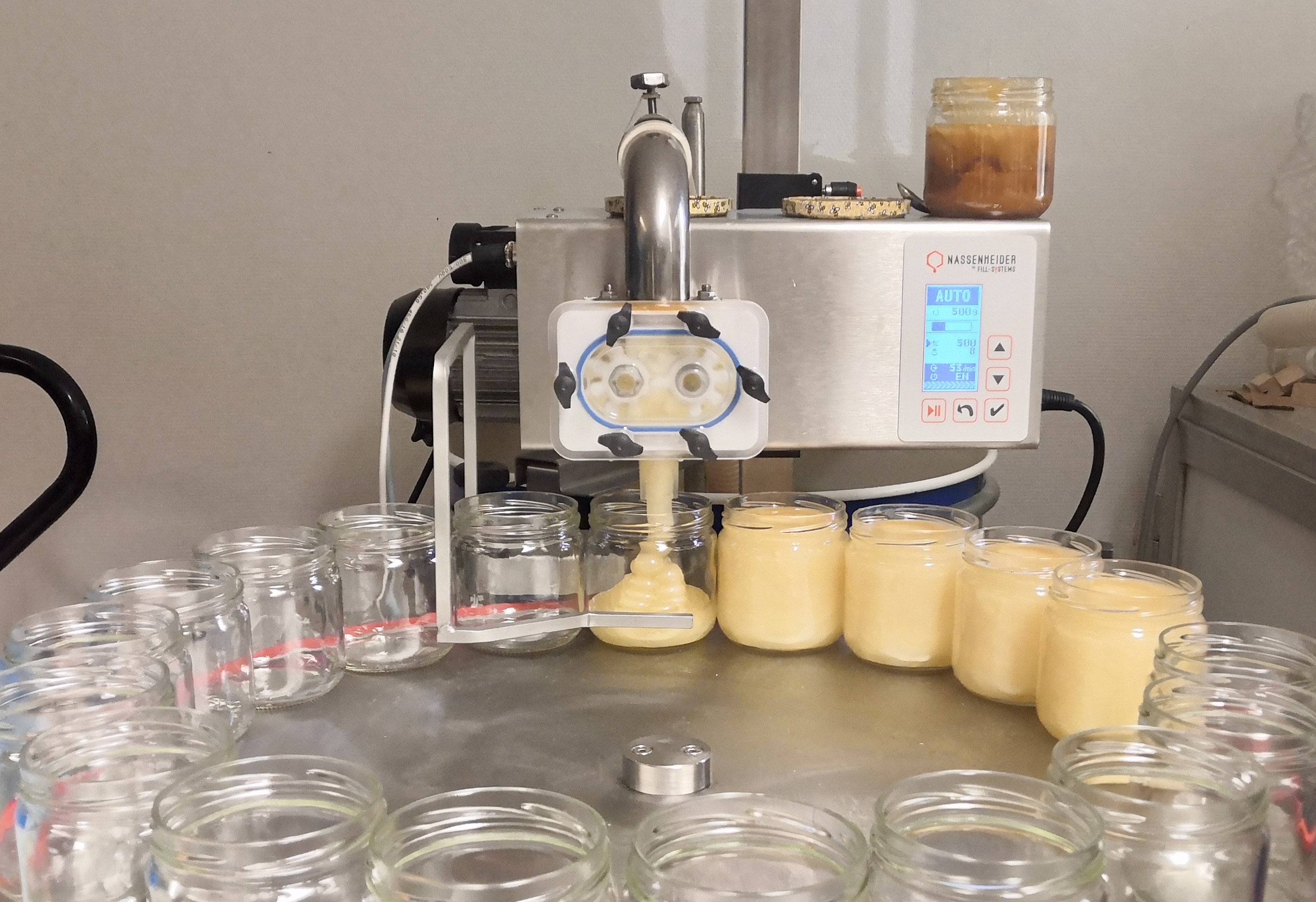 adding honey to a jar